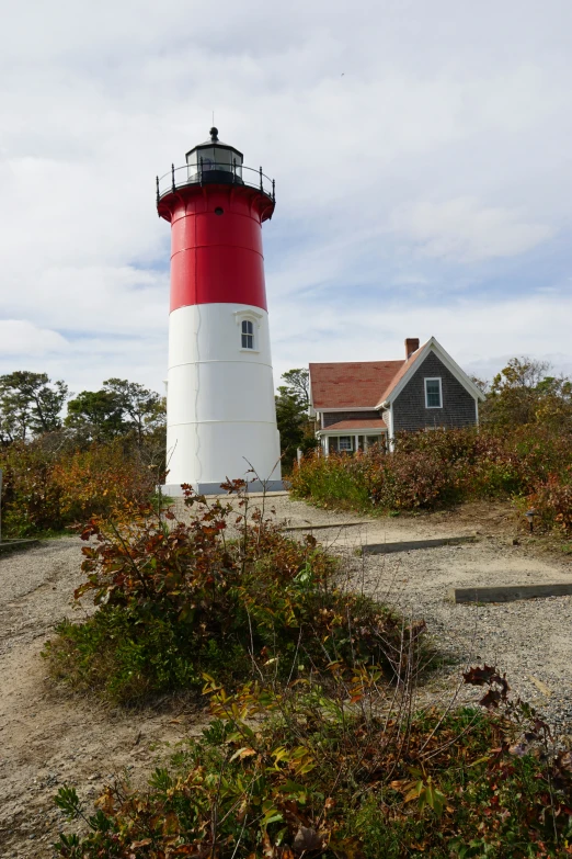 a red and white light house sitting in the dirt