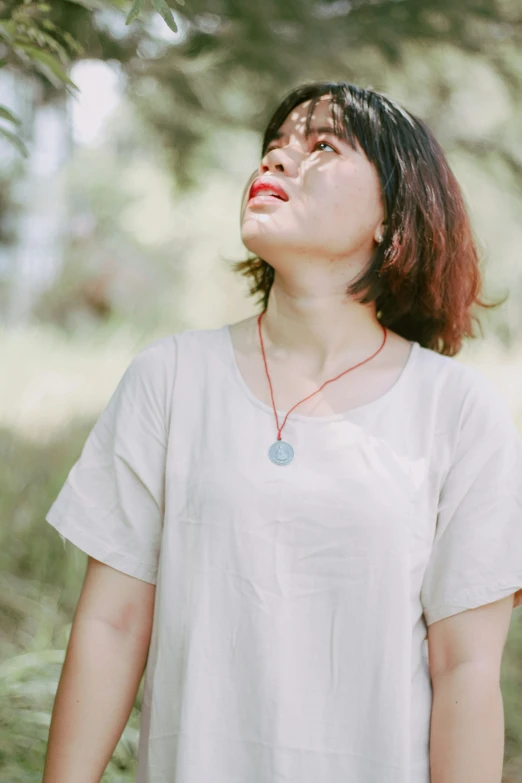 a woman with her eyes closed and a necklace in the air