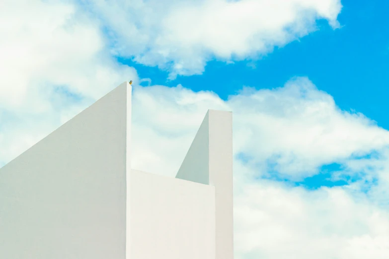 the architecture of a white building in a blue sky with clouds