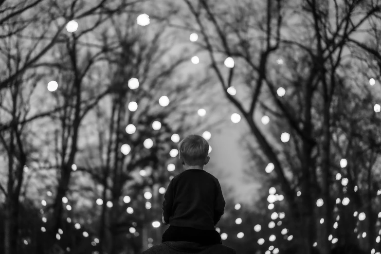 a  rides an elephant as the lights are suspended in the background