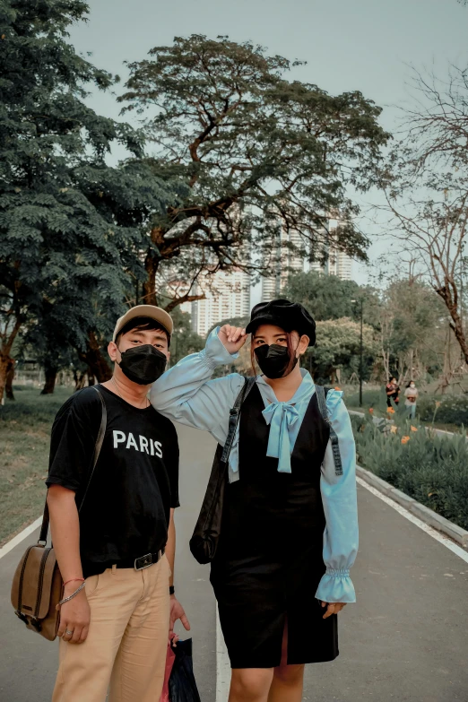 two people wearing masks are standing on a walkway