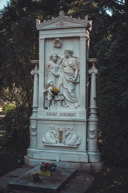 a monument with a vase on the base next to it