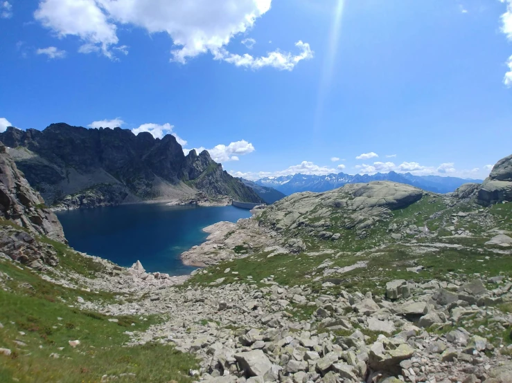 the sun shines brightly on a mountain lake in the background