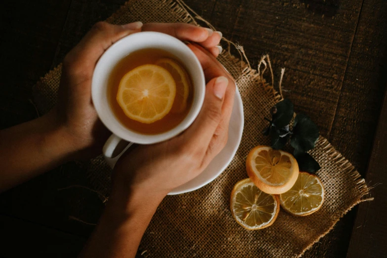 a person holding up a cup of tea