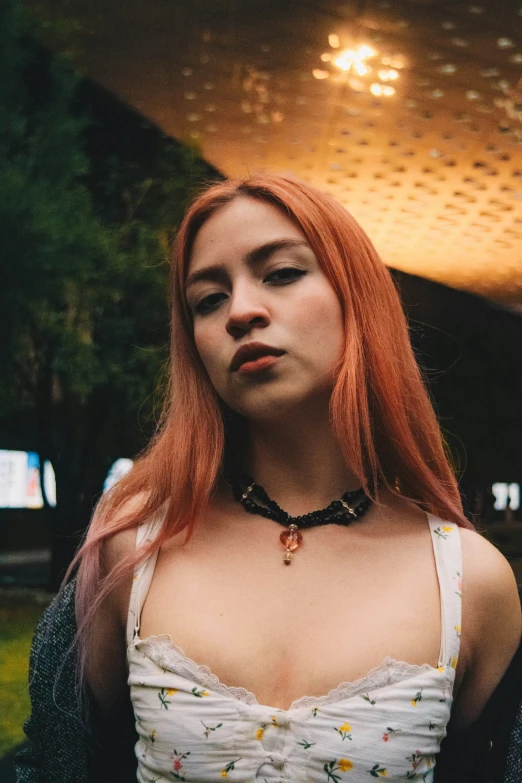 woman with long hair in white tank top looking off into the distance