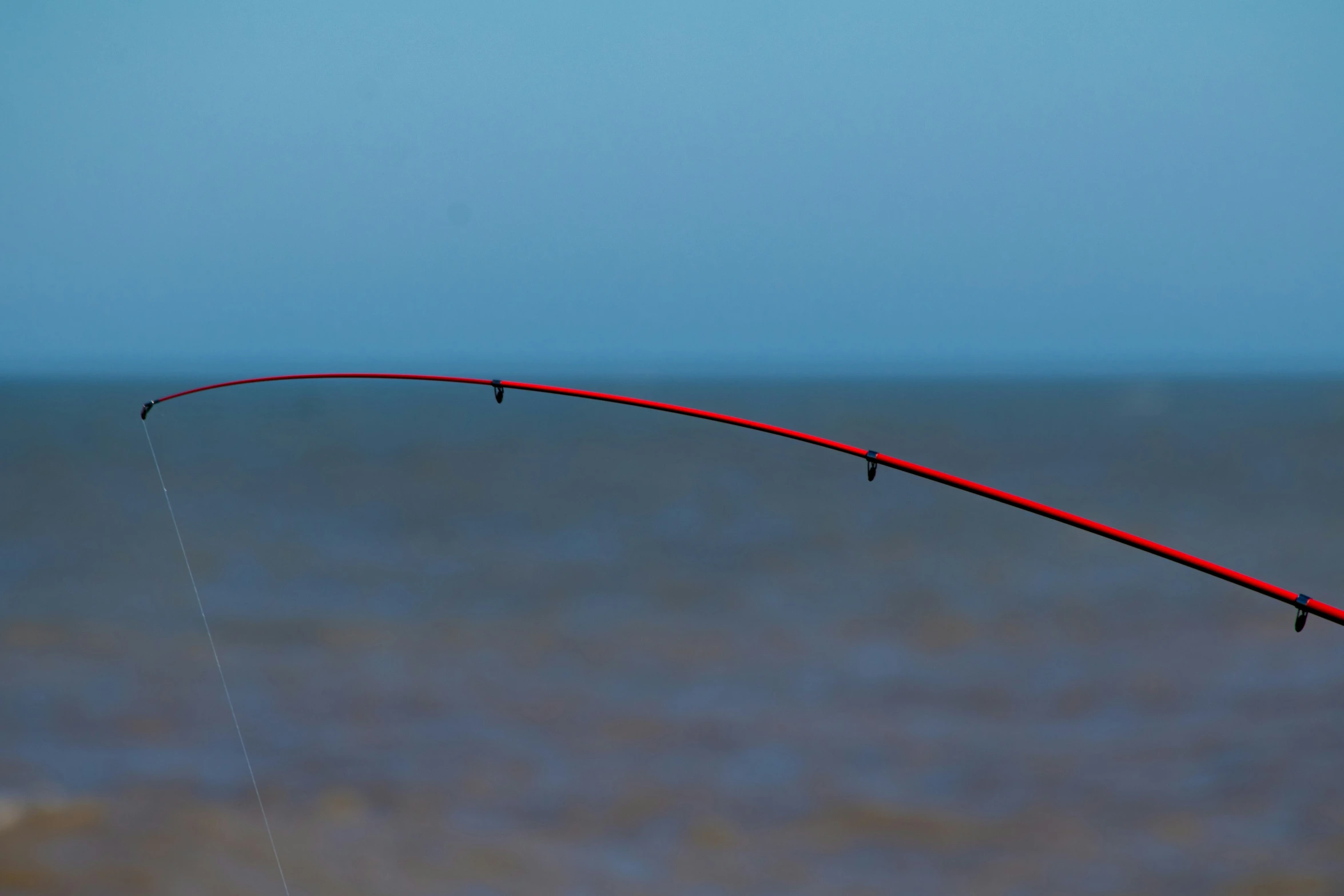 a man that is flying a kite next to water