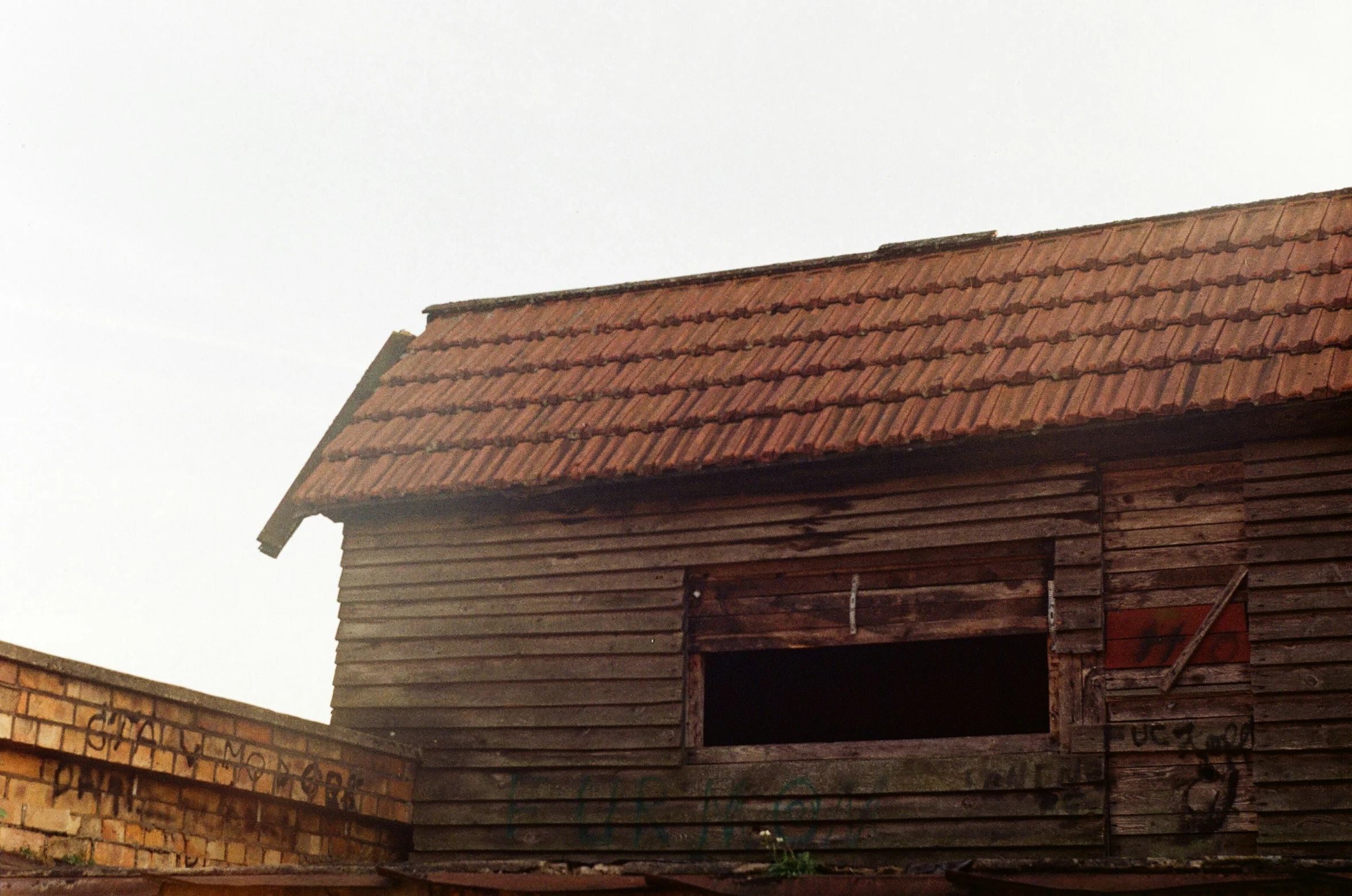 an old wood barn is shown with a missing window