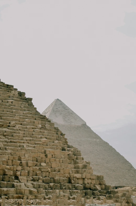 two people walking on steps next to a very tall stone pyramid