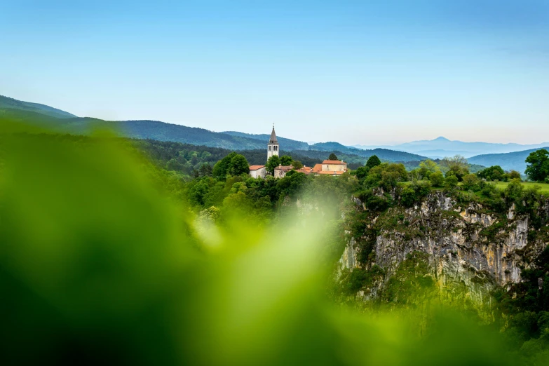 view over a hill in the mountains with green trees