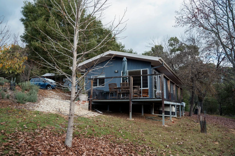 a large blue building on a hillside with some bushes in front of it