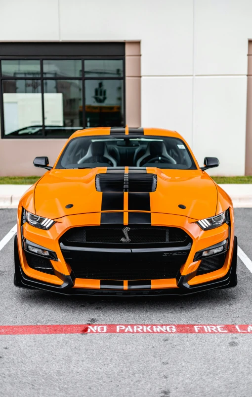 orange and black car sitting in front of a building