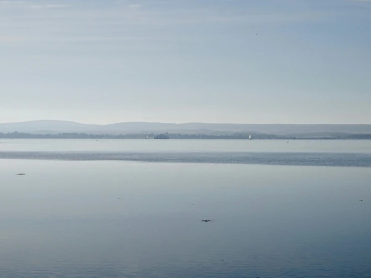 the calm waters in front of a mountain range