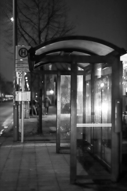 a bus stop at night with its lights on