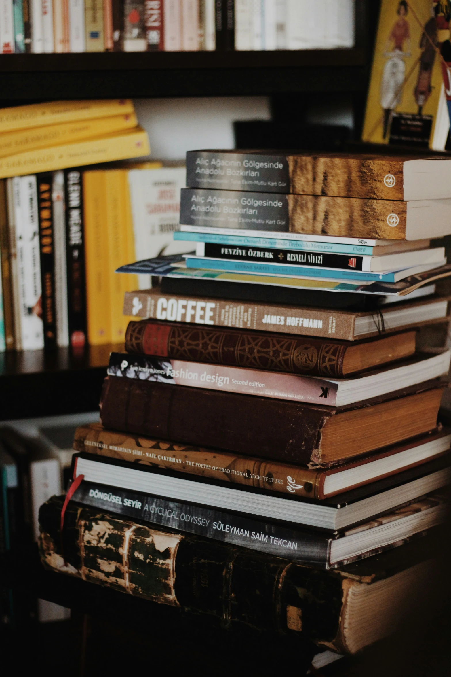 there are books stacked up against the bookshelf