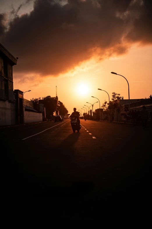 a man is driving down the street with a motorcycle