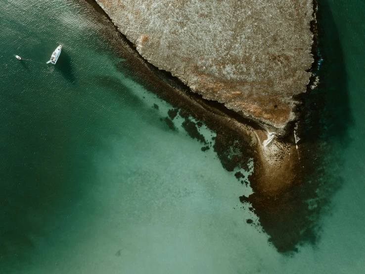 a sandy beach and rock out side at sea