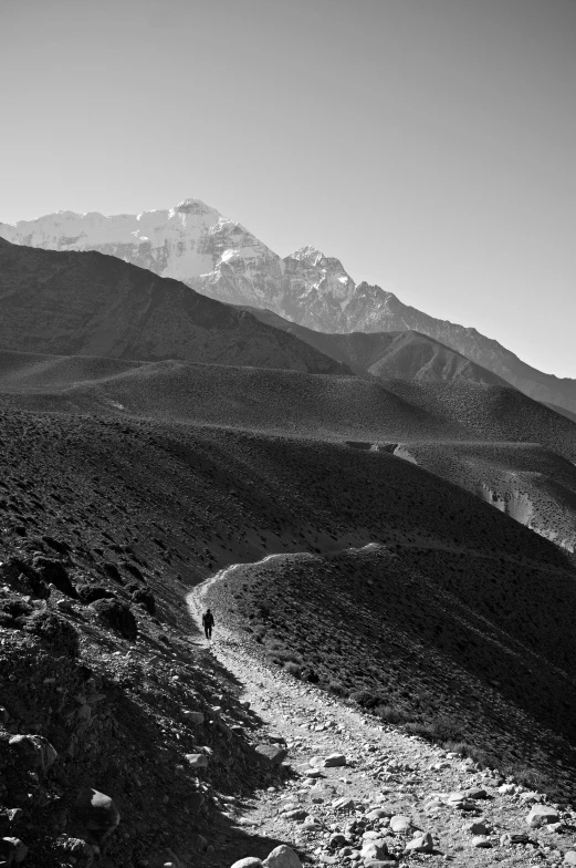 black and white pograph of mountain landscape with hiking man