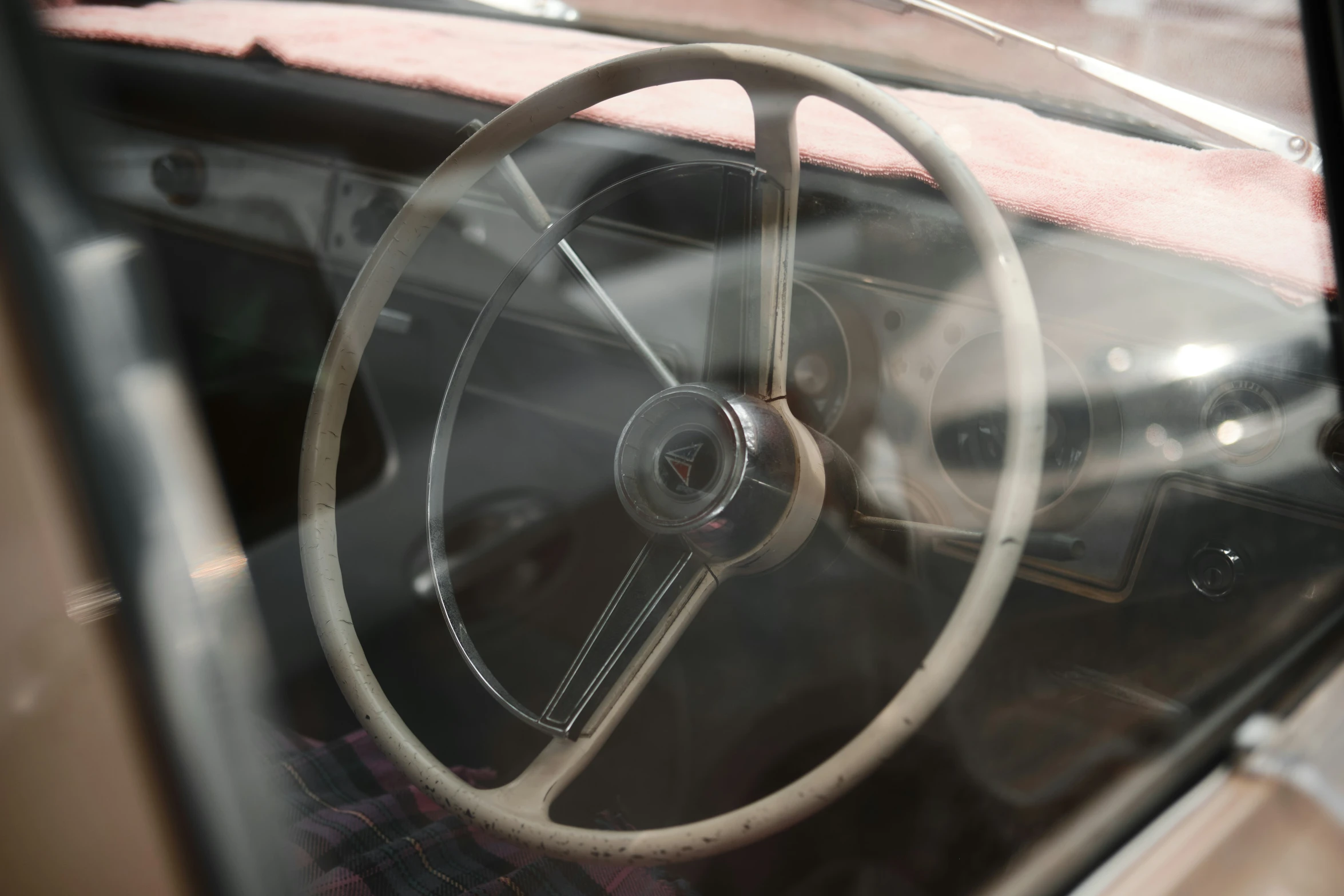 the steering wheel of a vintage car during the day