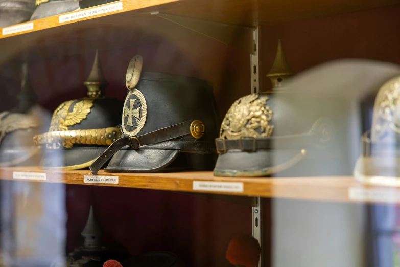 a number of hats on display behind glass