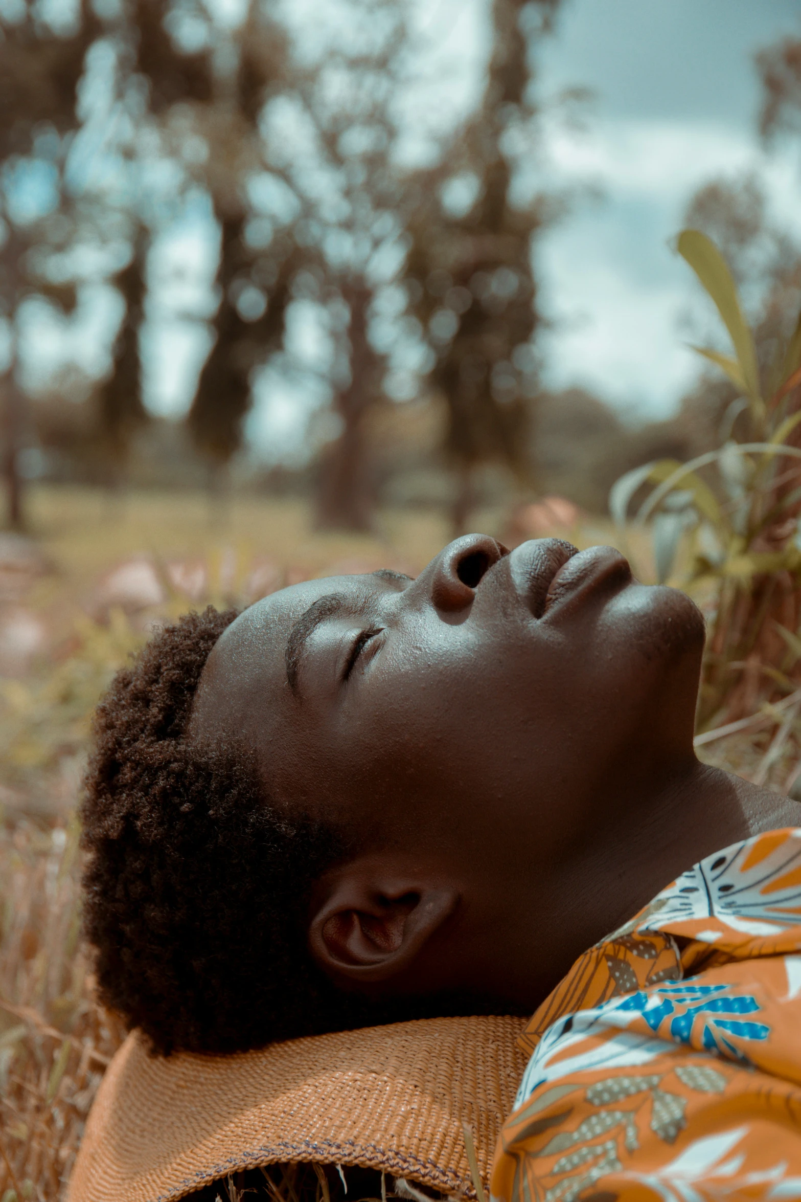 a close up of a child laying in a field