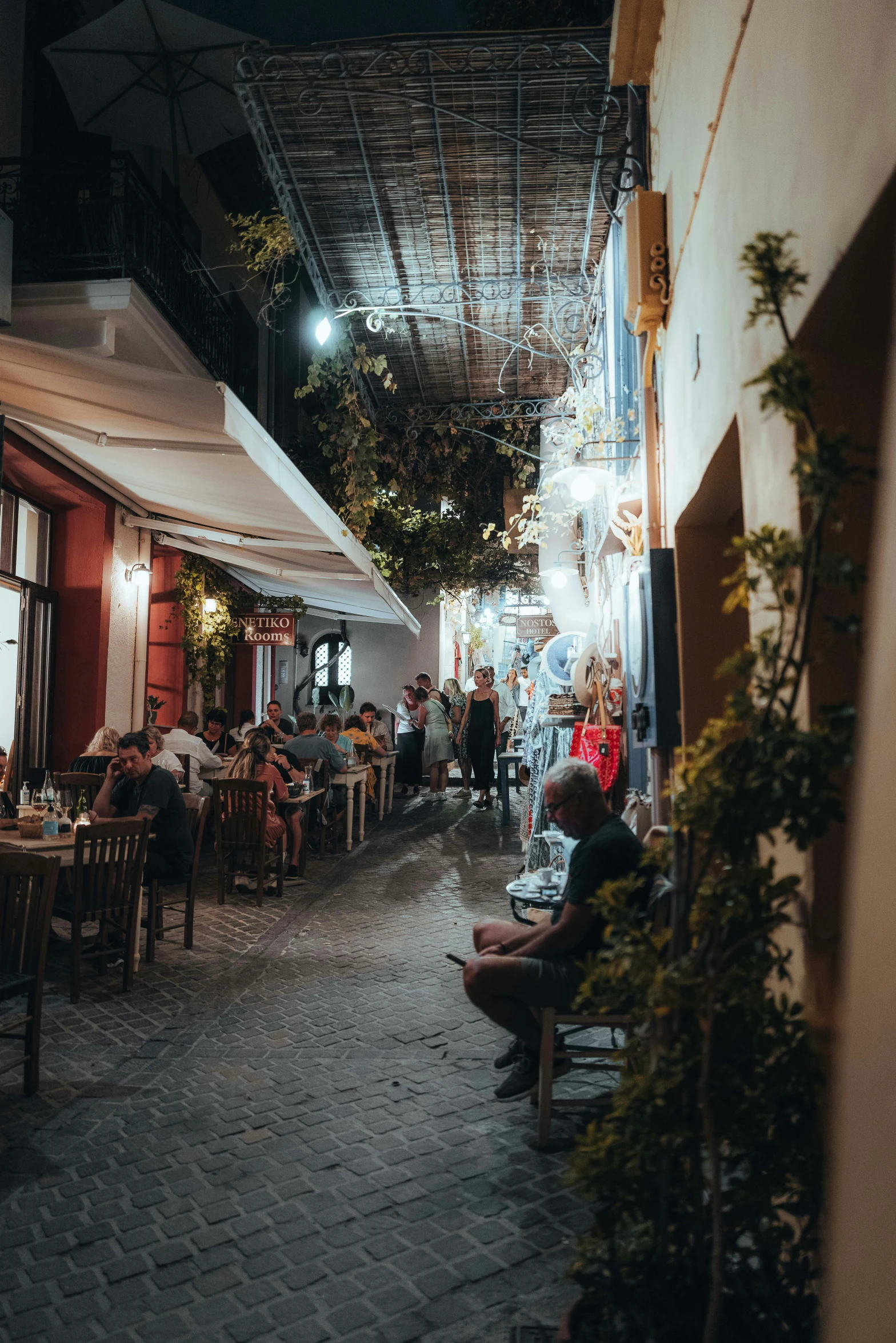 an alley with several people sitting down at tables