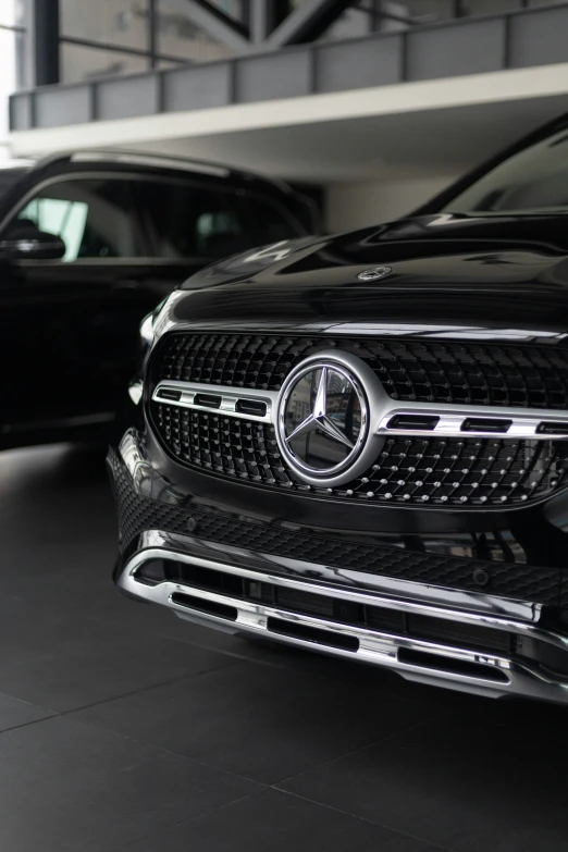 the front grilles of two cars are shown in an empty garage