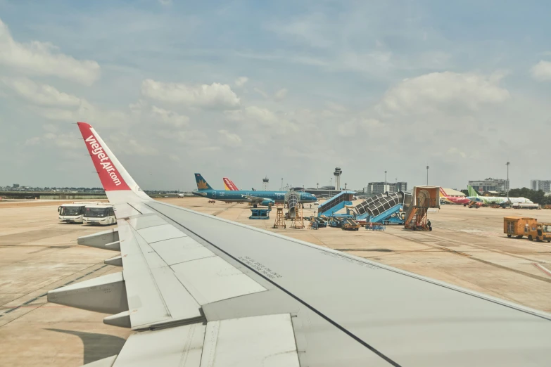 an airplane wing and some planes at the airport