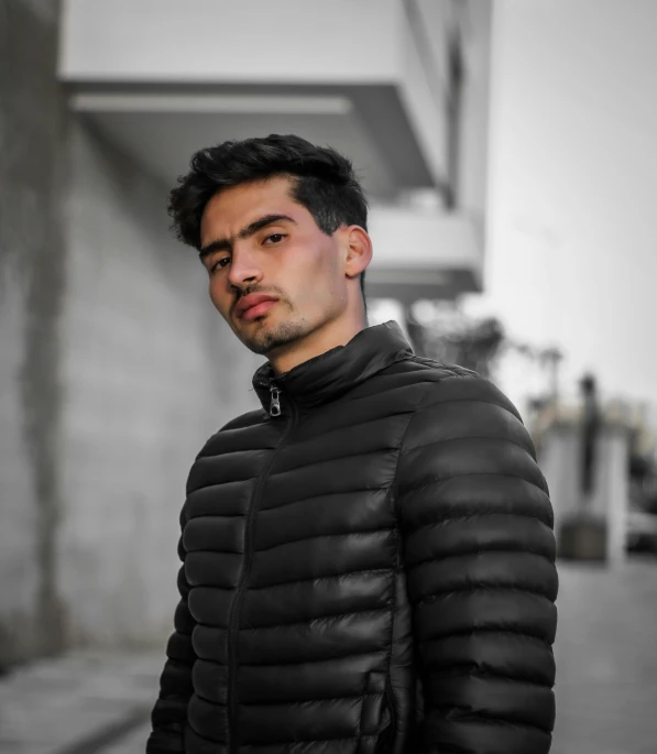 a man poses for the camera on a street corner