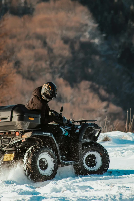 a person on an all terrain vehicle riding through the snow