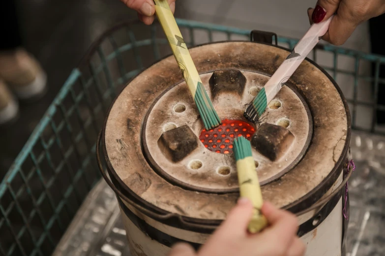 an asian woman is using a toothbrush to clean a drum