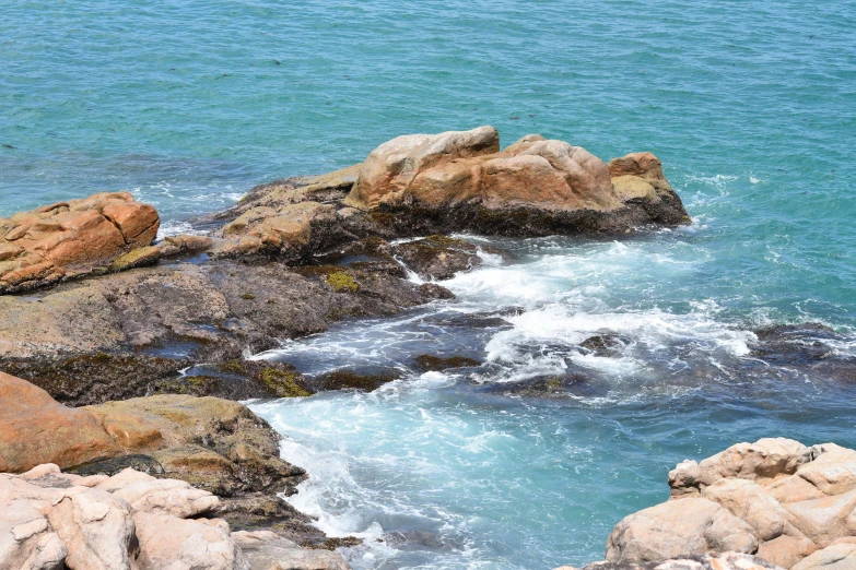 rocks are set in the water along side a large body of water