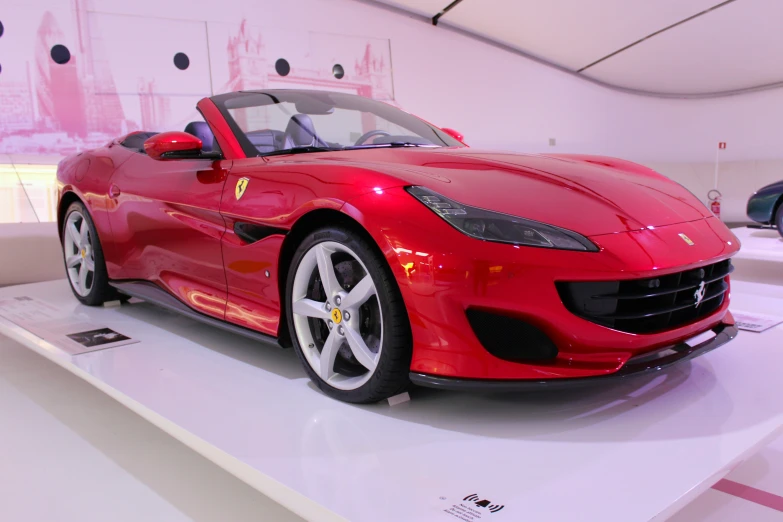 a red sports car with chrome rims is on display