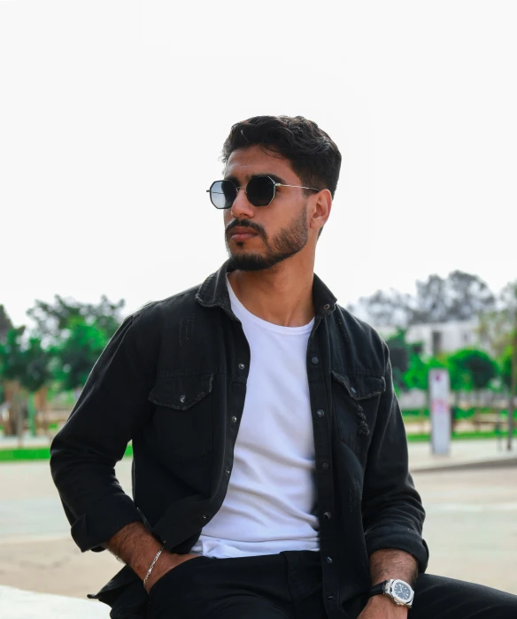 a man in sunglasses sitting on a bench in front of a building