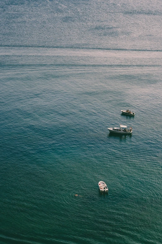 a group of boats floating on top of the ocean