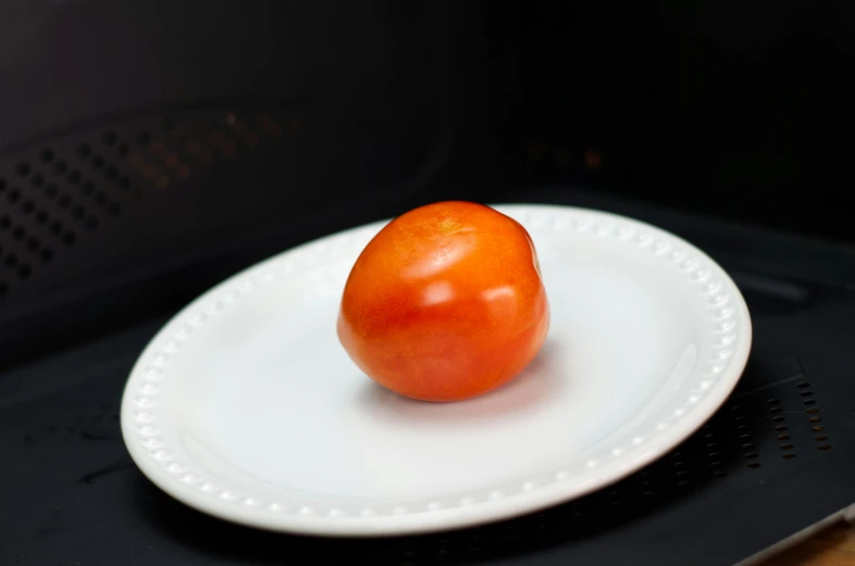 the tomato on the plate is waiting to be eaten