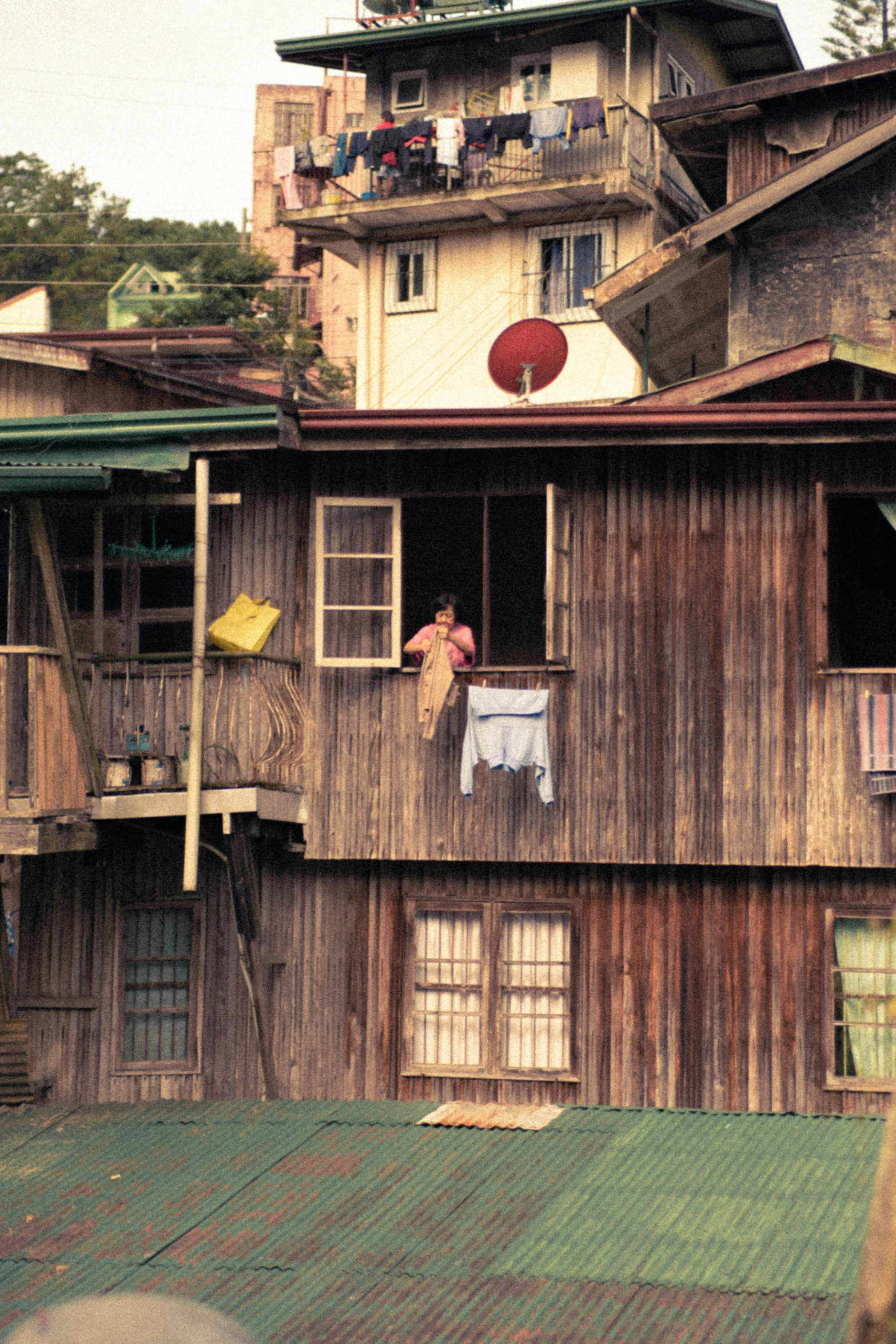 a person is hanging out of the windows of their house