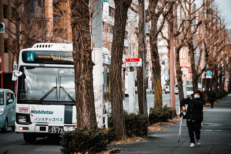 the person is walking on the street with his backpack behind him