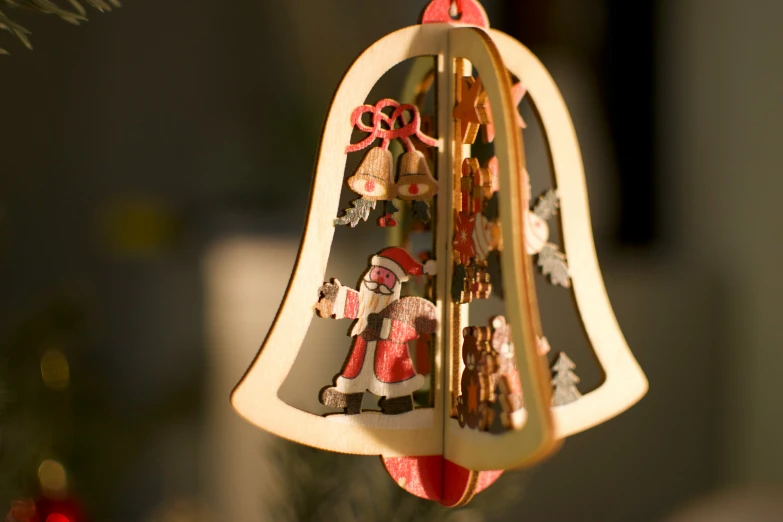 a bell shaped christmas ornament with a santa claus clause and reindeers