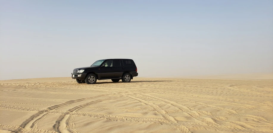 a four wheel drive vehicle on top of a sandy hill