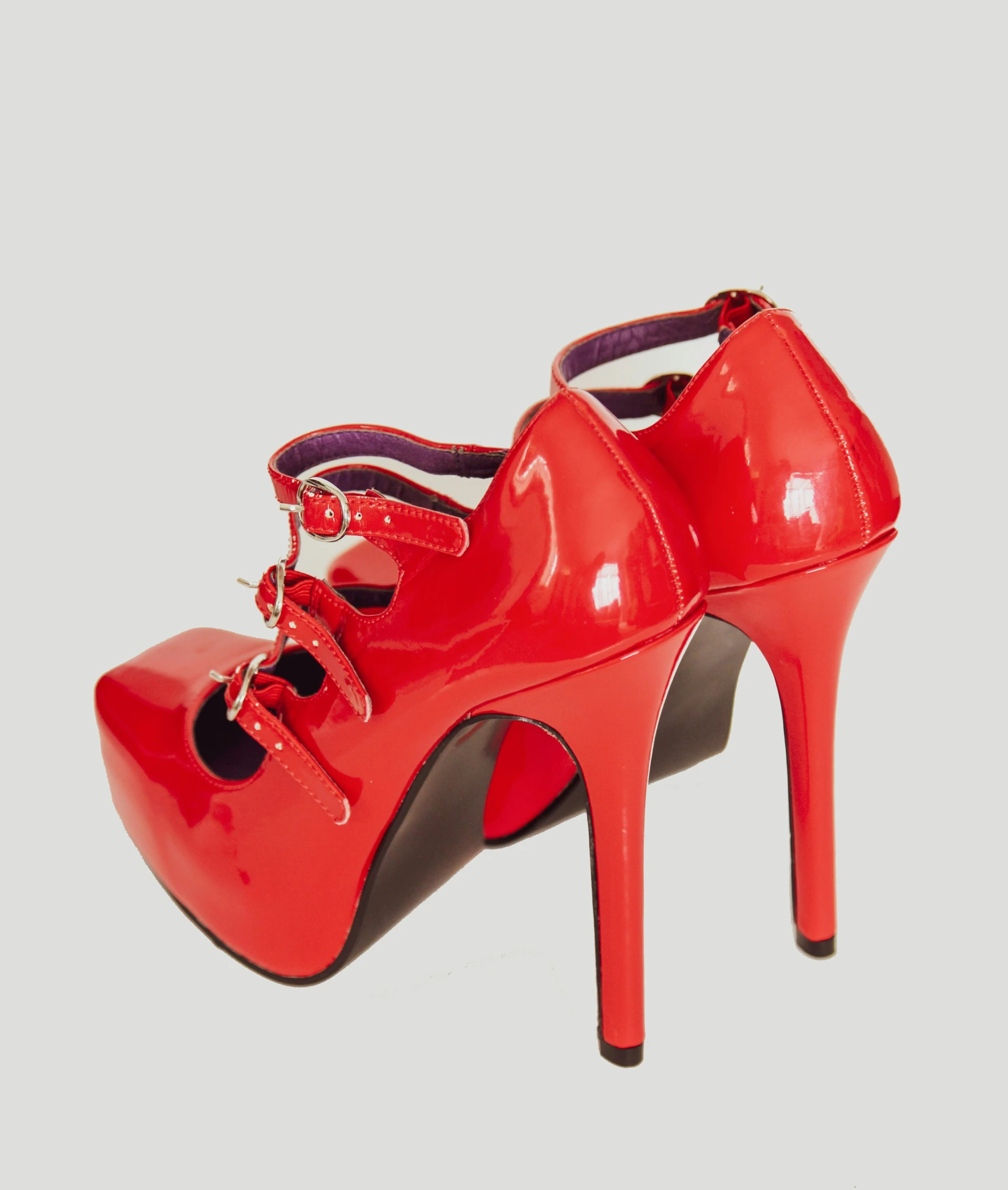 woman's red leather shoe with a high heel, tied at the ankle