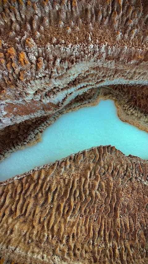 a pool is surrounded by rocky rocks and sand