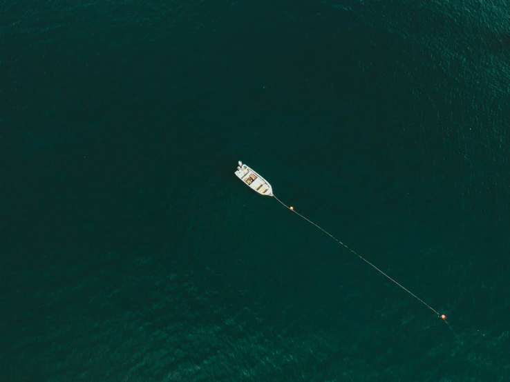 an aerial view of a boat sailing on a body of water