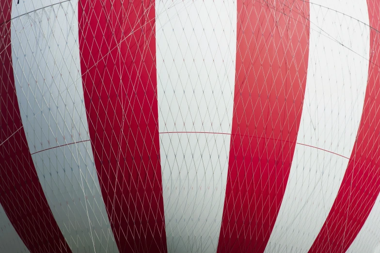 a large red and white striped balloon floating in the air