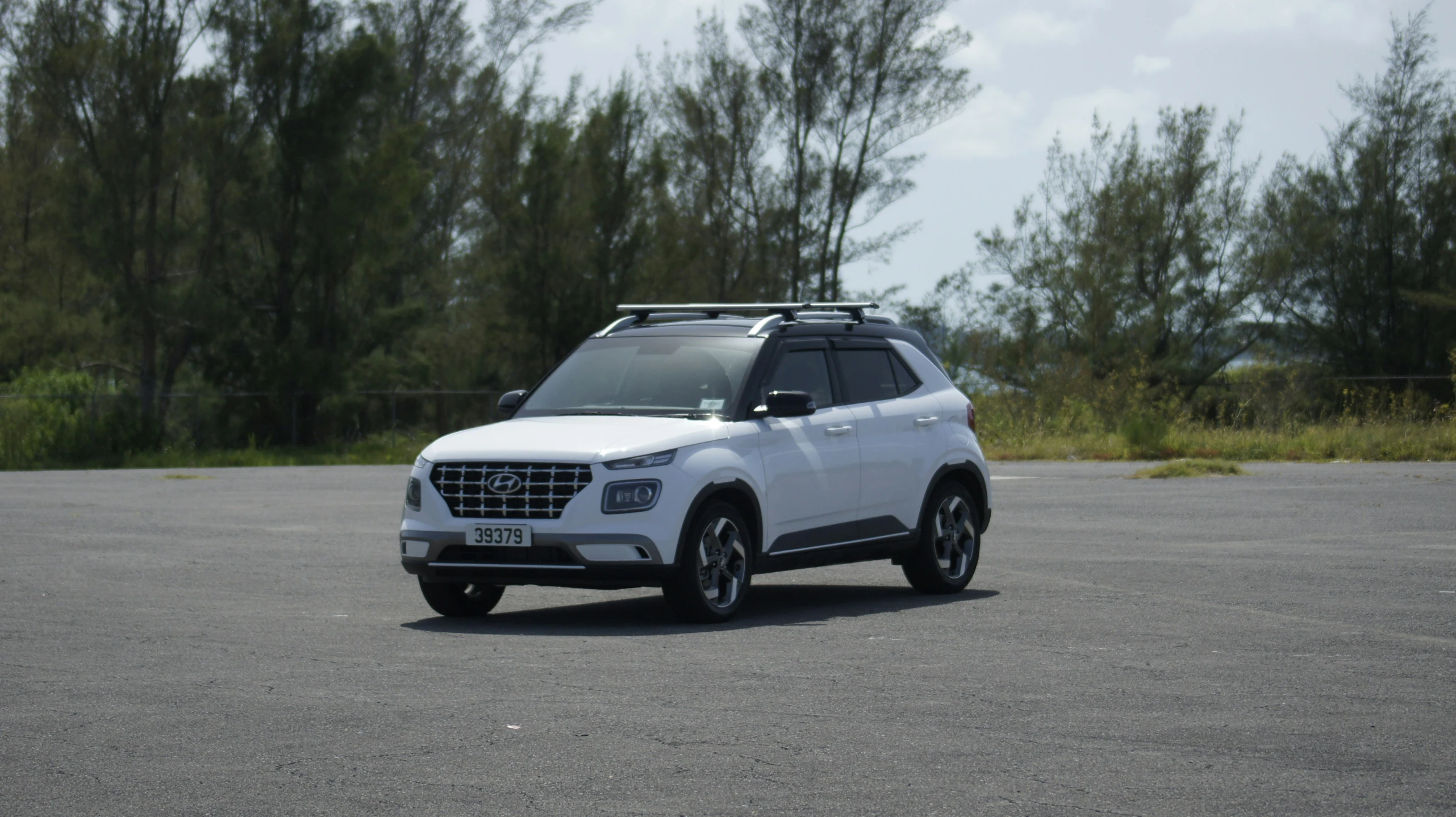 a suv parked in front of trees and a fence