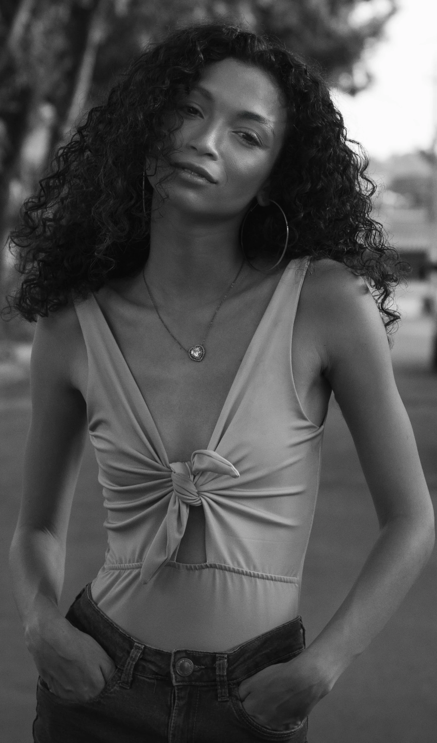 a woman standing on the street in a tank top