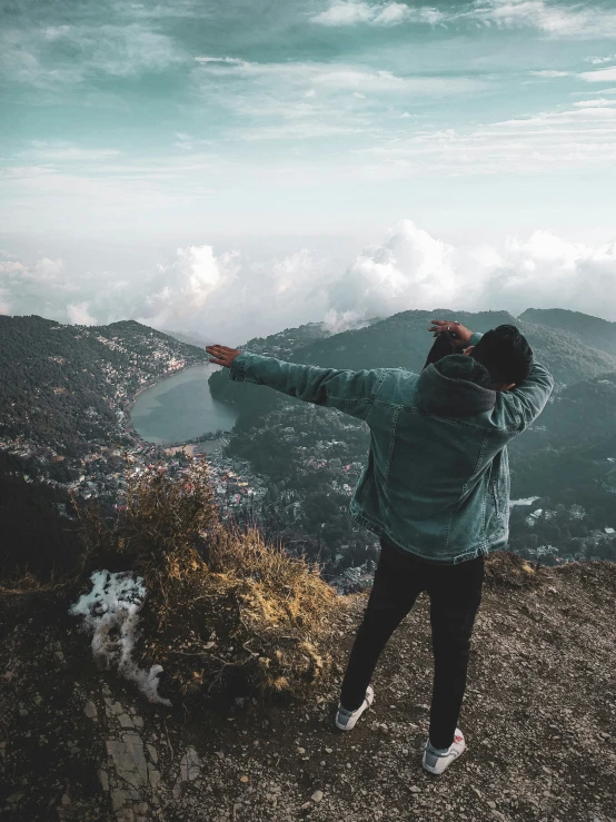 a person pointing at soing while on a mountain