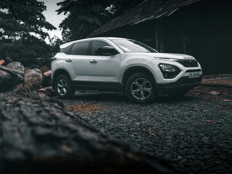 a white four - door car parked on a gravel road in the evening