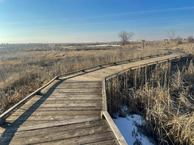 the boardwalk at a dry river bed is covered in snow