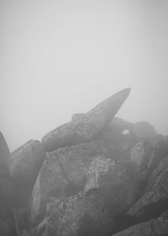 two large rocks with some small rocks in the background