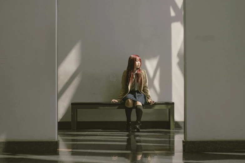 a woman is sitting on a bench in a building